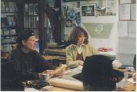 Man in beret and woman in glasses studying paperwork